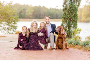 A family posing for a picture with their dog.